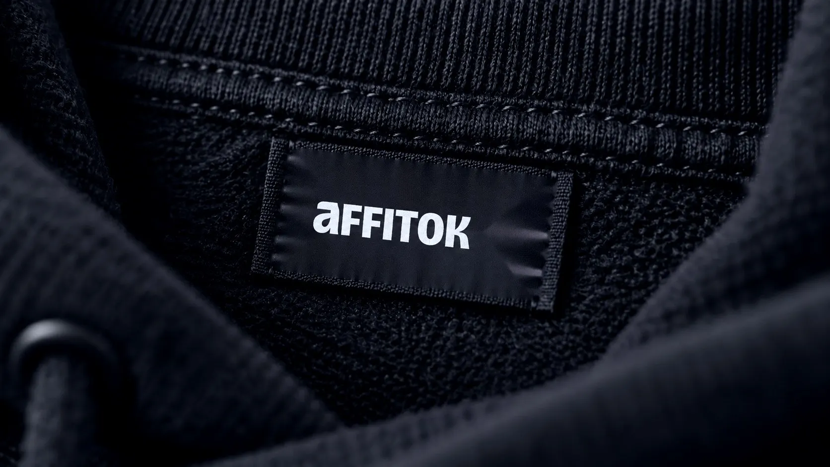 Black woven label with the wordmark